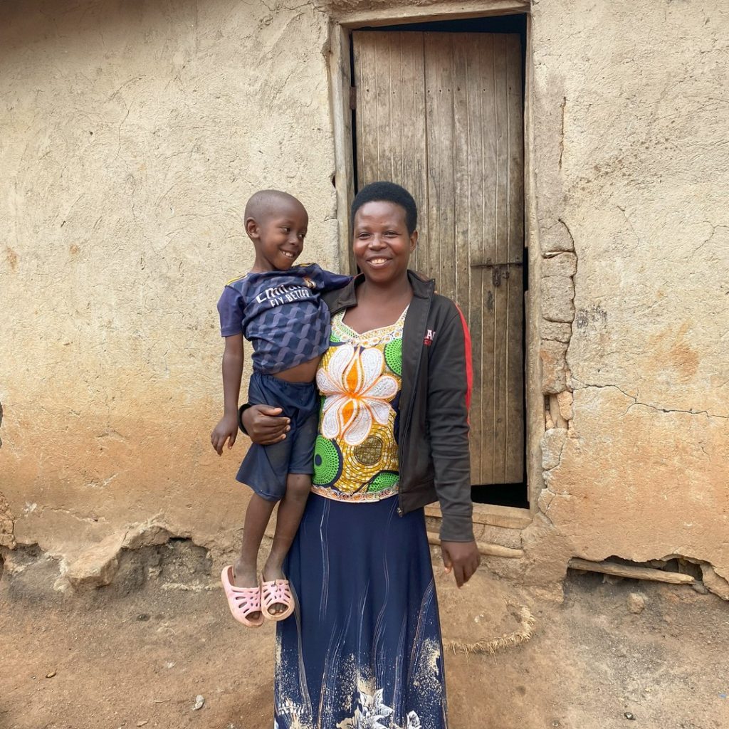 A woman standing carrying a young boy