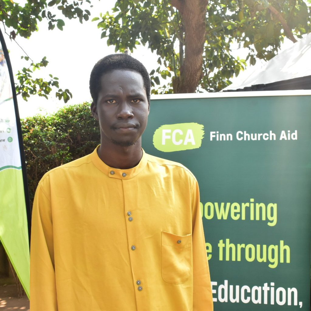Aman standing infront of a banner